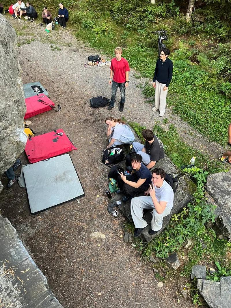 En gruppe ved en bergvegg i skogen, sett ovenfra
